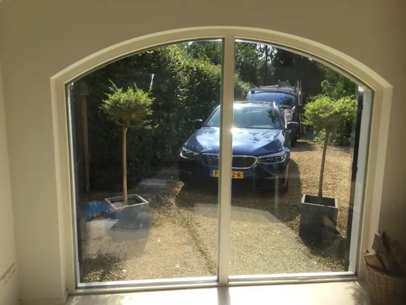 Boogvormige deur met groot gelaagd glas